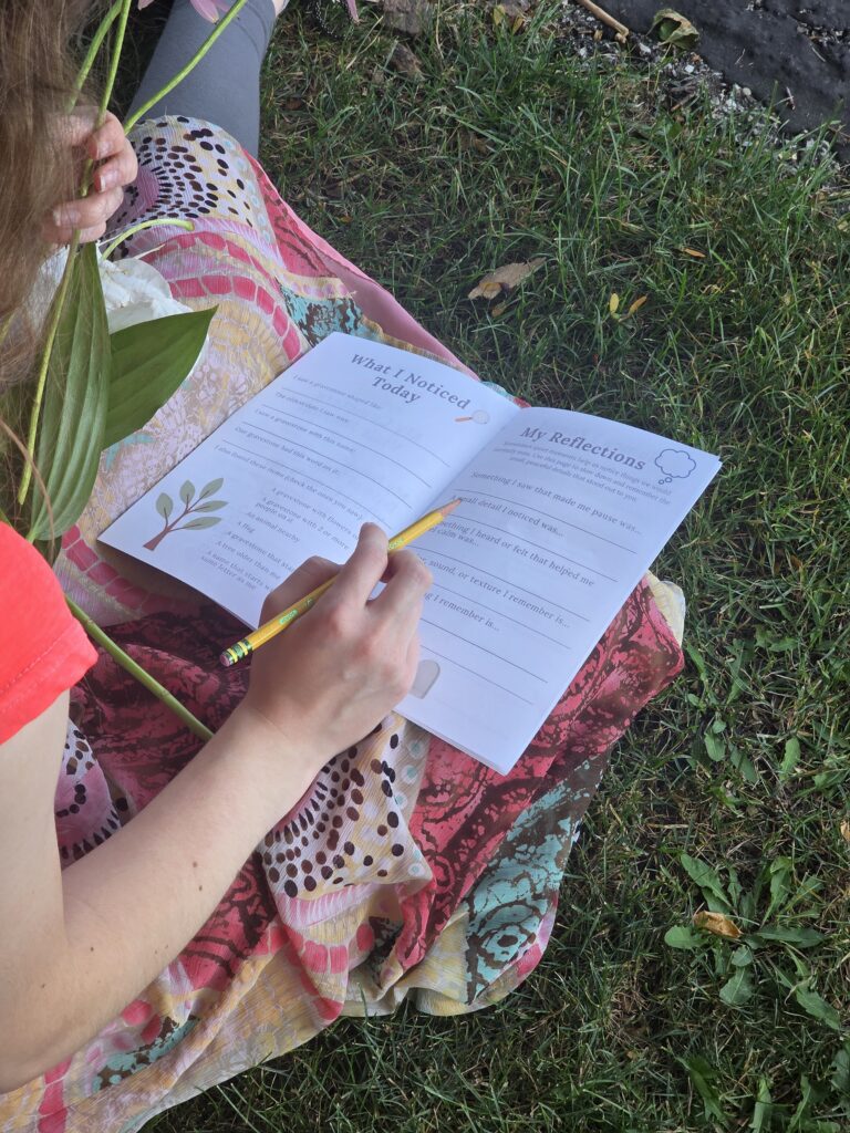 Cemetery Family Visit Journal in a lap with a hand holding a pencil above it.