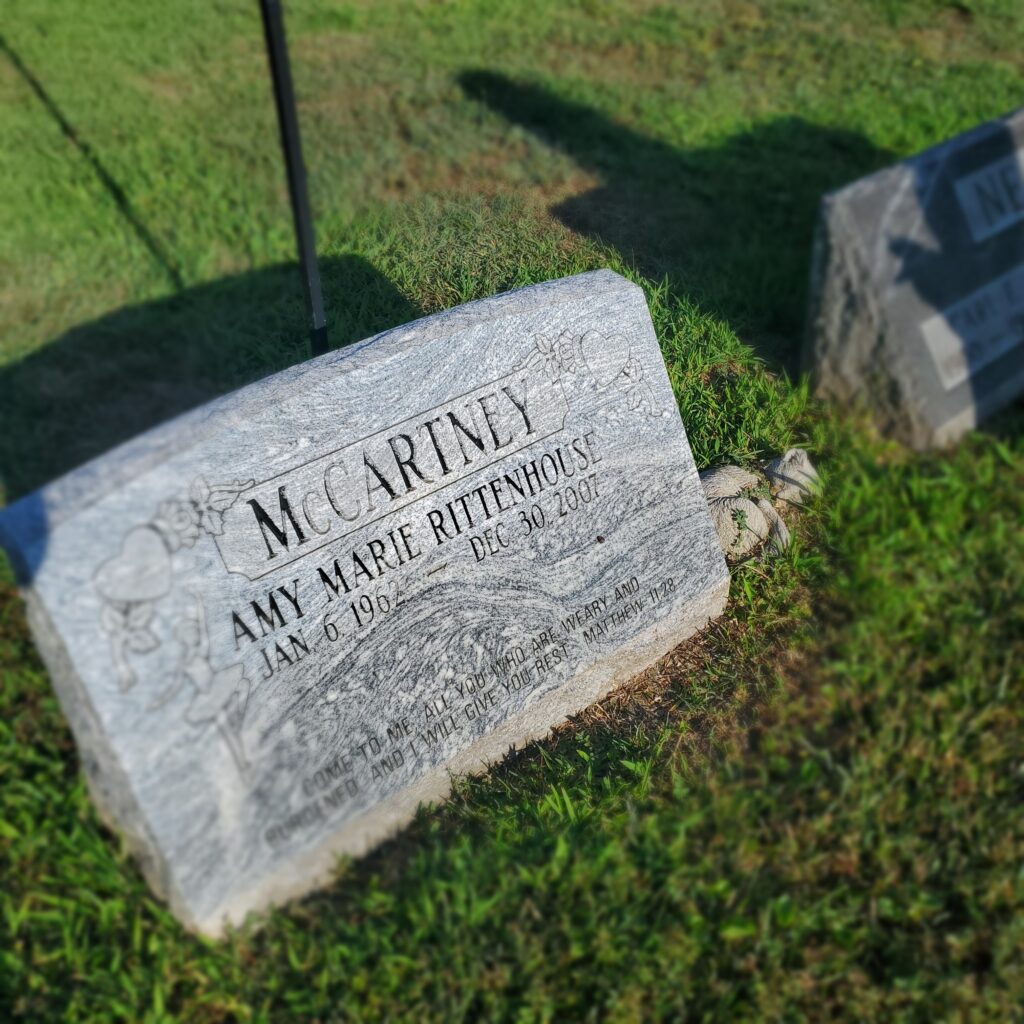 Gravestone photograph of headstone amid grass in a cemetery